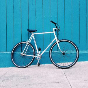 A bicycle parked in front of a blue wall.